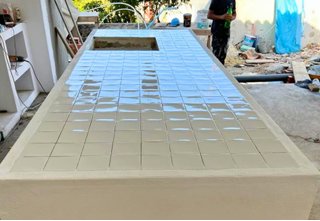 Piscina em construção com revestimento em azulejo branco