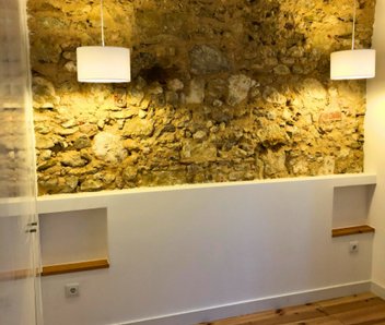 Sala com parede em pedra à vista e iluminação cálida