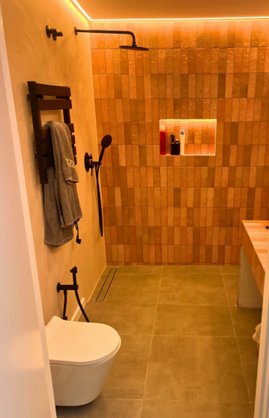 Casa de banho premium com azulejos terracota e iluminação LED
