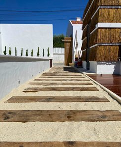 Caminho exterior com pavimento em madeira e brita — obra de arranjo exterior