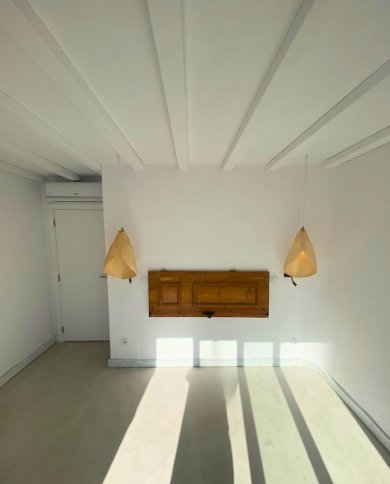 Sala minimalista com pendentes douradas e parede branca